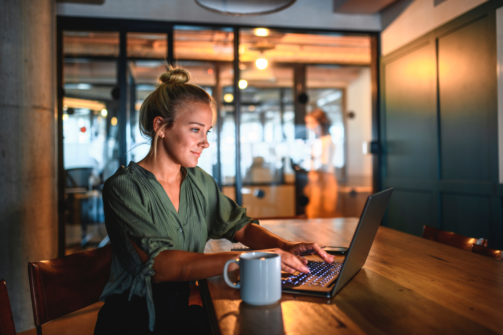 Woman working thoughtfully on her laptop