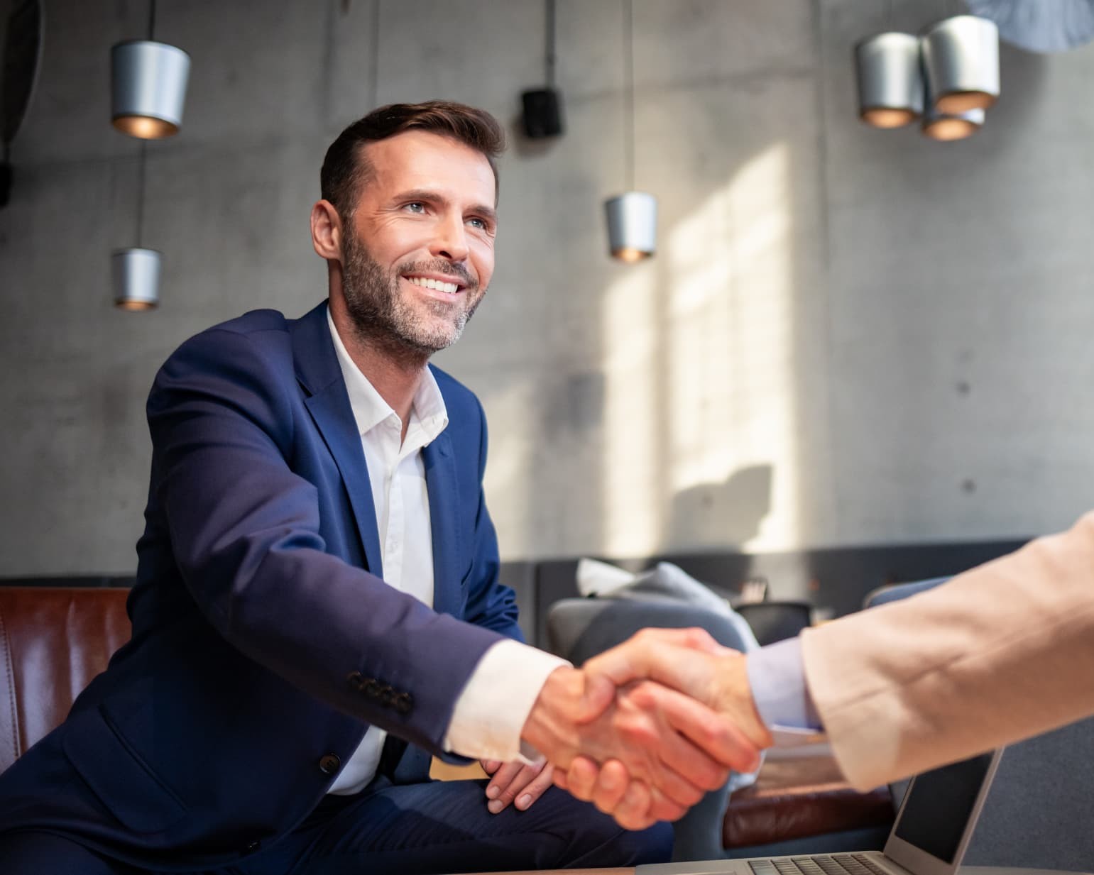 Businessman in a navy suit shaking hands with a client